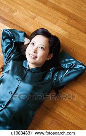 Stock Photo - High angle view of a young woman lying on the floor. Fotosearch