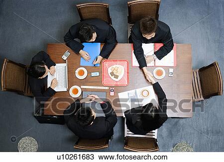 Stock Image - High angle view of five business executives in a meeting. Fotosearch