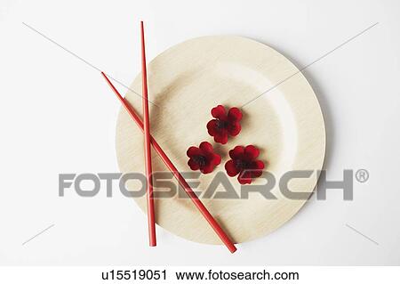 Stock Image - High angle view of flowers and a pair of chopsticks on a plate. Fotosearch