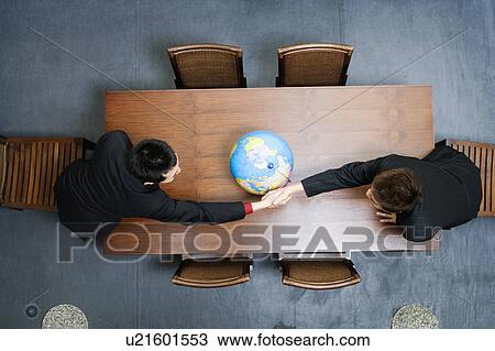 Stock Image - High angle view of two businessmen shaking hands. Fotosearch