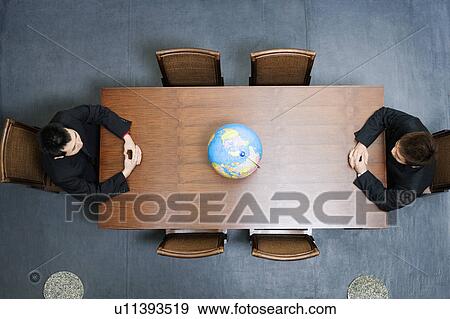 High angle view of two businessmen sitting at a conference table View Large Photo Image Stock Photo - High angle view of two businessmen sitting at a conference table. Fotosearch