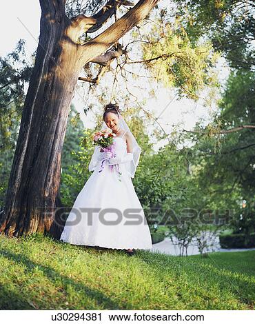 Low angle view of a young woman in the wedding dress View Large Photo Image Stock Image - Low angle view of a young woman in the wedding dress. Fotosearch
