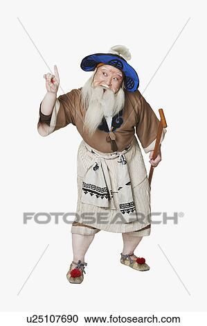 Stock Image - Mid adult man standing holding an oar. Fotosearch