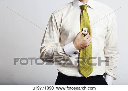 Stock Image - Mid section view of a businessman holding a cube of marble. Fotosearch