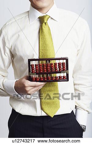 Stock Photo - Mid section view of a businessman holding an abacus. Fotosearch
