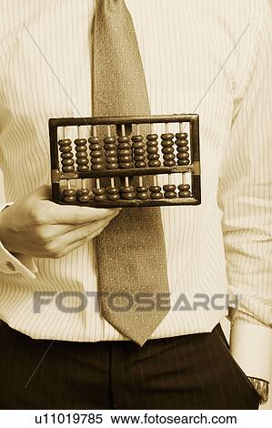 Stock Photography - Mid section view of a businessman holding an abacus. Fotosearch
