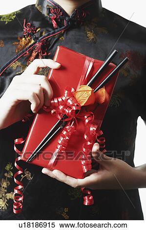Mid section view of a woman holding a gift in her hand View Large Photo Image Stock Photography - Mid section view of a woman holding a gift in her hand. Fotosearch
