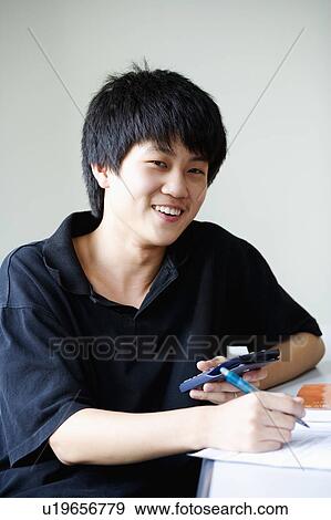 Stock Photo - Portrait of a boy smiling and holding a calculator. Fotosearch