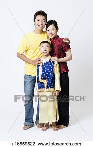 Stock Image - Portrait of a boy standing with his parents. Fotosearch