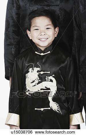 Stock Photograph - Portrait of a boy standing with his father smiling. Fotosearch