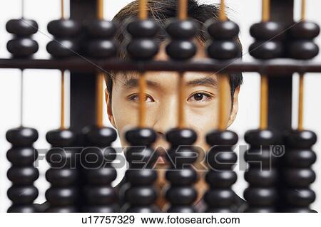 Portrait of a businessman behind an abacus View Large Photo Image Stock Photo - Portrait of a businessman behind an abacus. Fotosearch