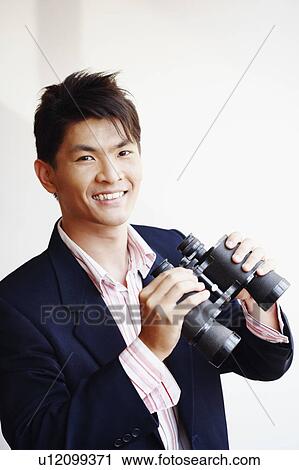 Portrait of a businessman holding a pair of binoculars and smiling View Large Photo Image Stock Image - Portrait of a businessman holding a pair of binoculars and smiling. Fotosearch