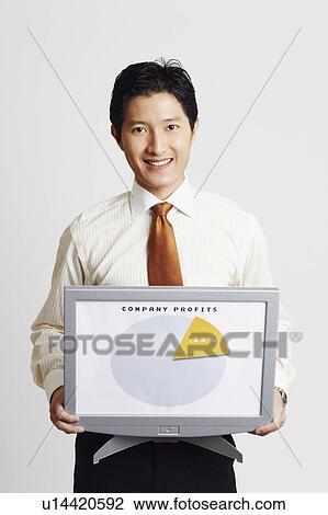 Portrait of a businessman holding a model of a computer monitor and showing a progress report View Large Photo Image Stock Image - Portrait of a businessman holding a model of a computer monitor and showing a progress report. Fotosearch
