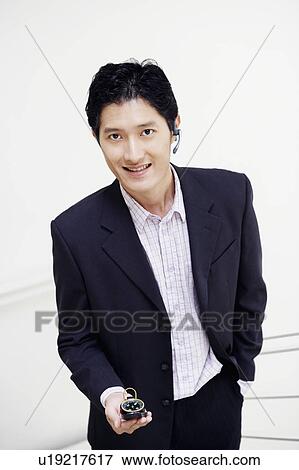 Portrait of a businessman holding a compass and wearing a hands-free device View Large Photo Image Stock Photo - Portrait of a businessman holding a compass and wearing a hands-free device. Fotosearch