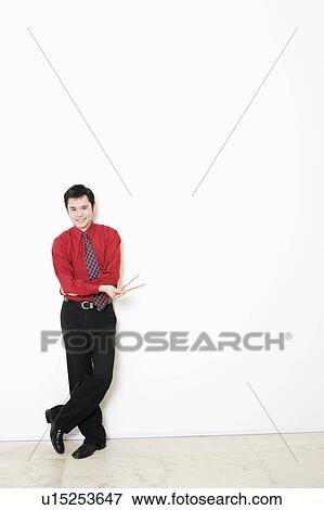 Stock Photo - Portrait of a businessman standing and smiling. Fotosearch