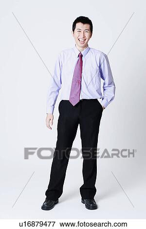 Stock Photo - Portrait of a businessman standing with his hands in his pockets. Fotosearch