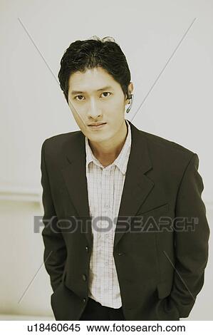 Stock Photography - Portrait of a businessman standing with his hands in his pockets. Fotosearch