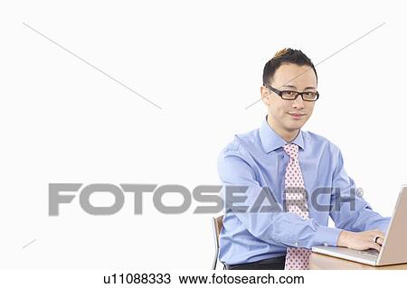 Stock Image - Portrait of a businessman using a laptop. Fotosearch