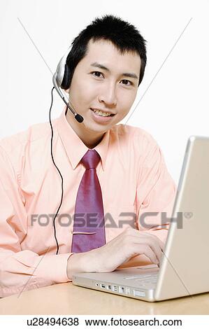 Stock Photo - Portrait of a businessman using a laptop. Fotosearch