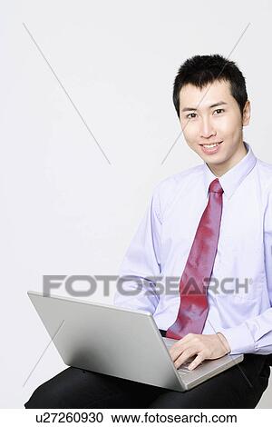 Portrait of a businessman using a laptop and smiling View Large Photo Image Stock Image - Portrait of a businessman using a laptop and smiling. Fotosearch