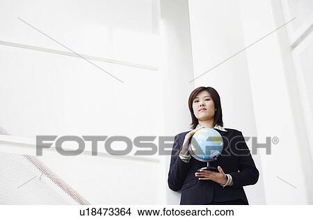 Picture - Portrait of a businesswoman holding a globe. Fotosearch