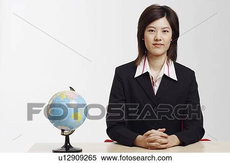Stock Photography - Portrait of a businesswoman sitting at a table in an office. Fotosearch
