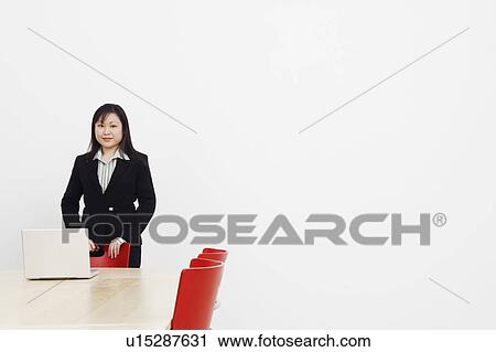Portrait of a businesswoman standing in a board room and smiling View Large Photo Image Stock Image - Portrait of a businesswoman standing in a board room and smiling. Fotosearch