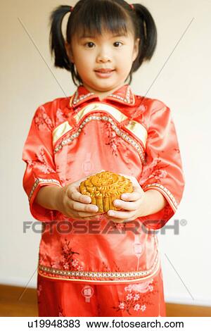 Stock Image - Portrait of a girl holding a cake. Fotosearch