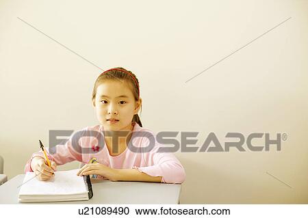 Portrait of a girl holding a pen on a spiral notebook in the classroom View Large Photo Image Stock Image - Portrait of a girl holding a pen on a spiral notebook in the classroom. Fotosearch