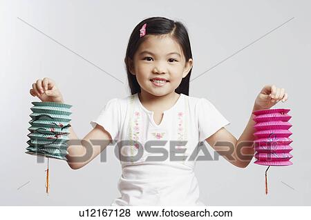 Stock Photo - Portrait of a girl holding two Chinese lanterns and smiling. Fotosearch