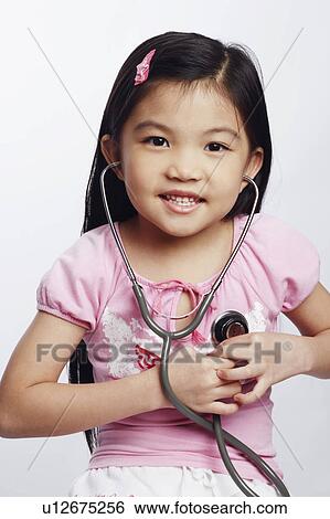 Portrait of a girl listening to her heart beat with a stethoscope View Large Photo Image Stock Photograph - Portrait of a girl listening to her heart beat with a stethoscope. Fotosearch