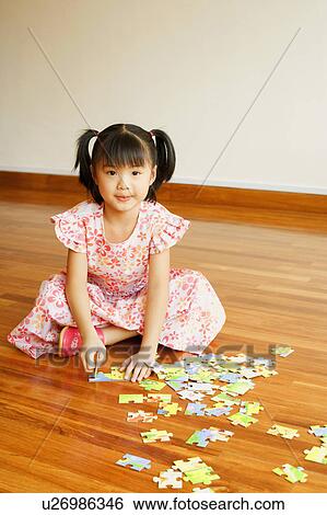 Portrait of a girl playing with a jigsaw puzzle View Large Photo Image Stock Photograph - Portrait of a girl playing with a jigsaw puzzle. Fotosearch