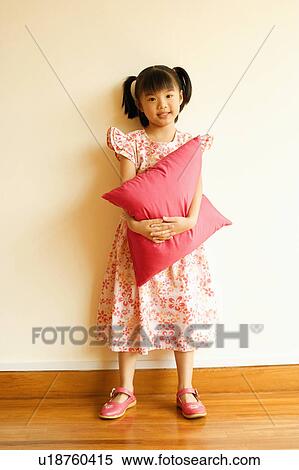 Portrait of a girl smiling and holding a pillow View Large Photo Image Stock Photography - Portrait of a girl smiling and holding a pillow. Fotosearch