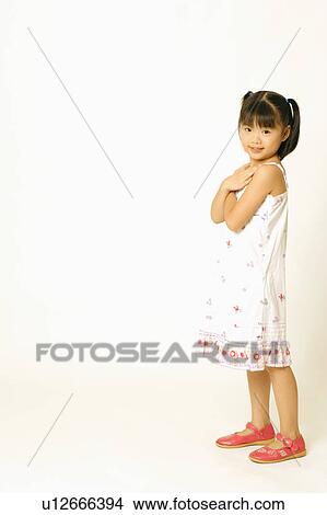 Portrait of a girl standing and hugging herself View Large Photo Image Picture - Portrait of a girl standing and hugging herself. Fotosearch