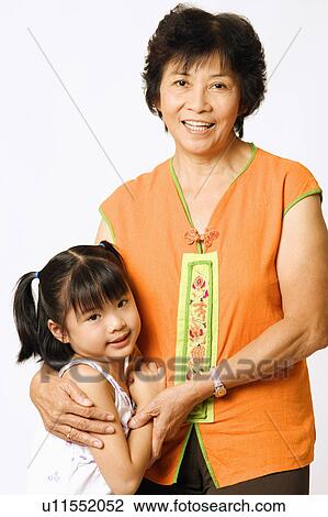 Stock Image - Portrait of a girl standing with her grandmother. Fotosearch