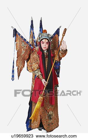 Stock Image - Portrait of a male Chinese opera performer holding a weapon. Fotosearch