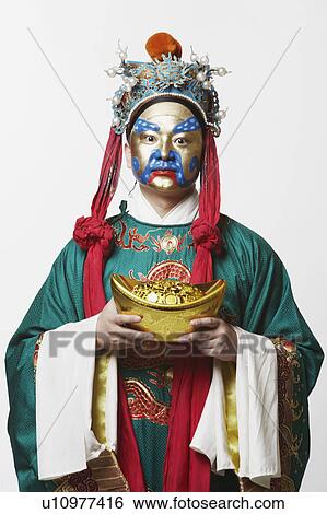 Stock Photograph - Portrait of a male Chinese opera performer holding a bowl full of gold coins. Fotosearch