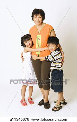 Portrait of a mature woman standing with her grandson and a granddaughter View Large Photo Image Stock Photograph - Portrait of a mature woman standing with her grandson and a granddaughter. Fotosearch