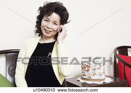 Stock Image - Portrait of a mature woman talking on a mobile phone. Fotosearch