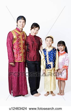 Picture - Portrait of a mid adult man and a young woman standing with their children. Fotosearch