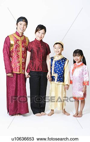 Stock Image - Portrait of a mid adult man and a young woman standing with their children. Fotosearch