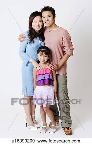 Portrait of a mid adult man and a young woman standing with their daughter View Large Photo Image Stock Photo - Portrait of a mid adult man and a young woman standing with their daughter. Fotosearch
