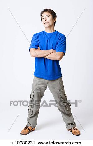 Stock Image - Portrait of a mid adult man standing with his arms crossed. Fotosearch