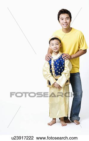 Stock Image - Portrait of a mid adult man standing with his son. Fotosearch
