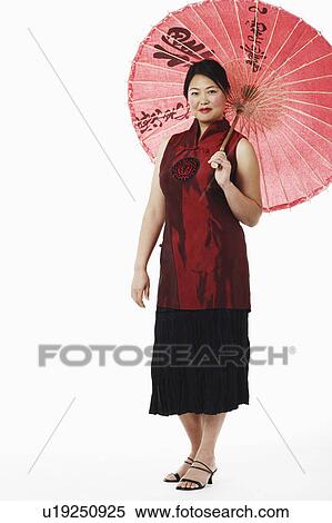 Stock Photography - Portrait of a mid adult woman holding a parasol. Fotosearch