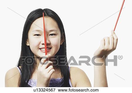 Stock Photo - Portrait of a teenage girl holding chopsticks. Fotosearch