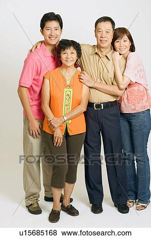 Stock Photo - Portrait of a young couple standing with their parents. Fotosearch