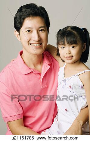 Portrait of a young man carrying his daughter View Large Photo Image Stock Photography - Portrait of a young man carrying his daughter. Fotosearch