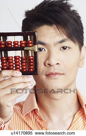 Stock Photography - Portrait of a young man holding an abacus. Fotosearch