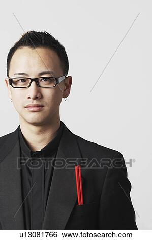 Stock Photograph - Portrait of a young man with a pair of chopsticks in his pocket. Fotosearch